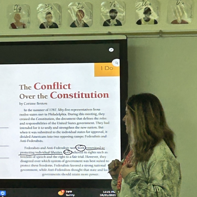 Teacher at the smart board modeling with mentor text  