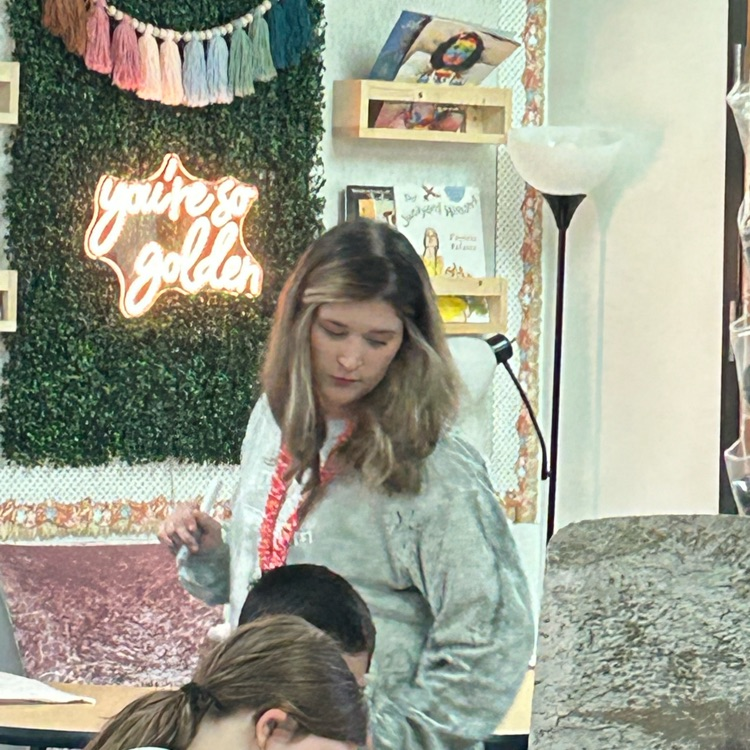 Teacher helping students as they work  