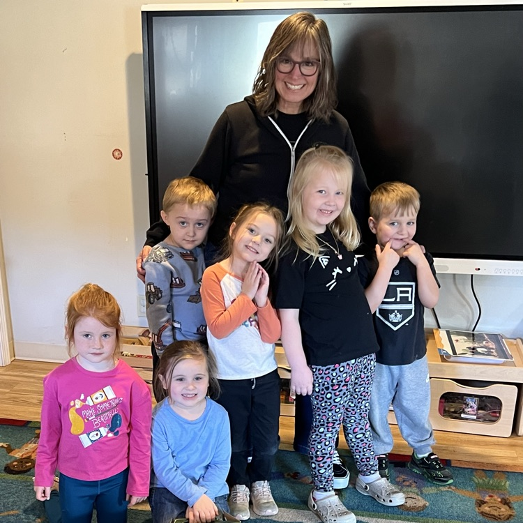 professional educator posing with young children.