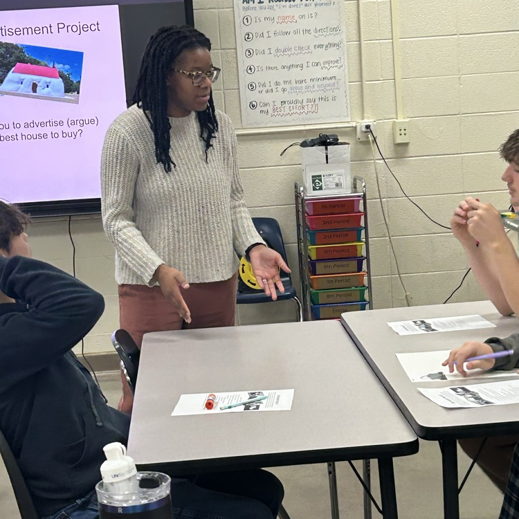 Teacher supporting small groups of students working on a project  