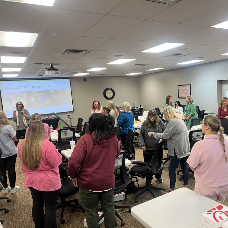 Early childhood providers participate in a group activity while discussing outdoor learning ideas.