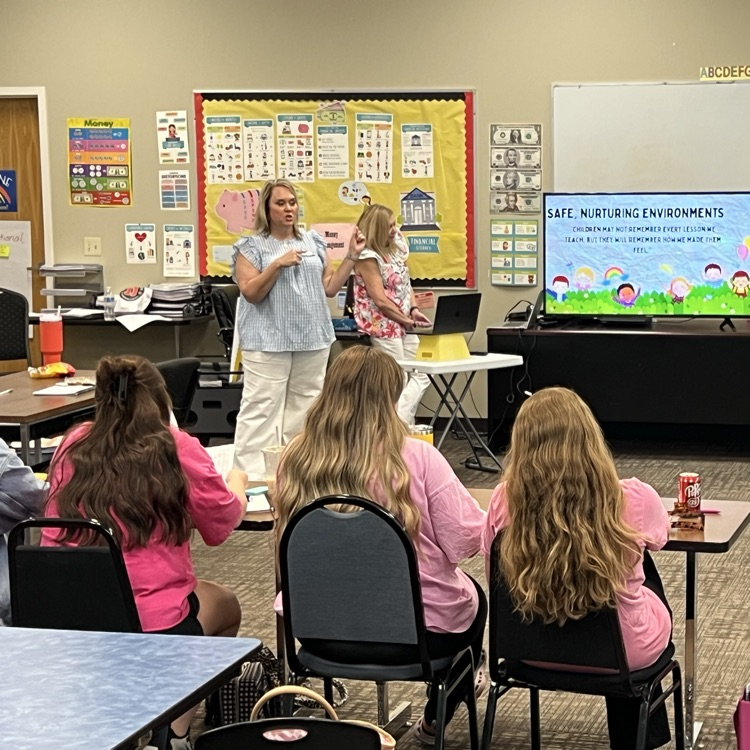 Two early childhood professionals presenting professional development to educators in a classroom setting.
