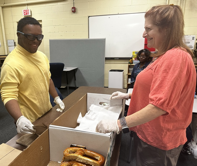 ADS student and staff member preparing pretzel orders.