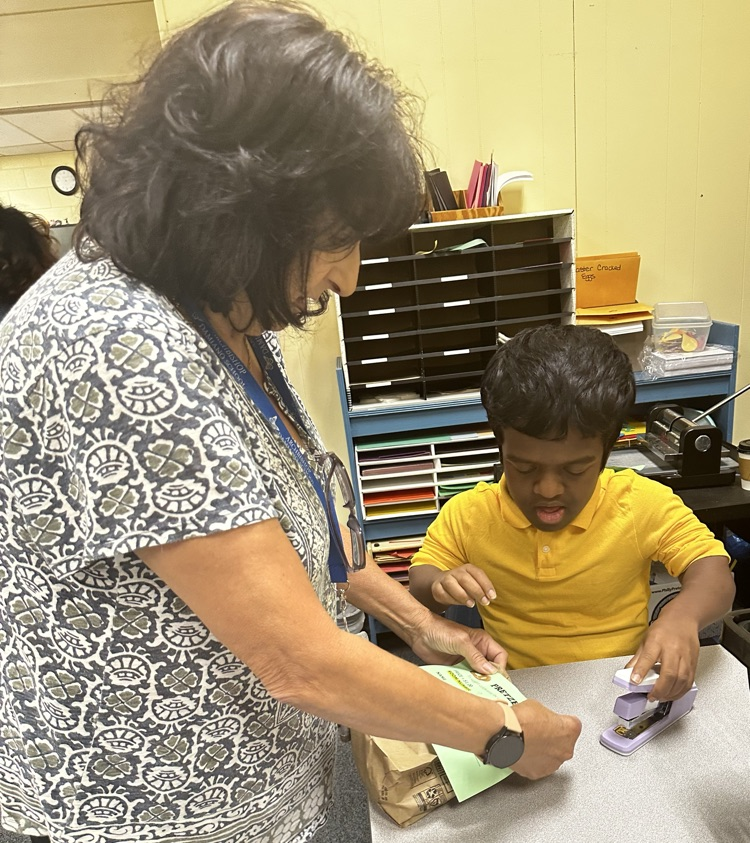 Staff member assisting student with preparing pretzel order.