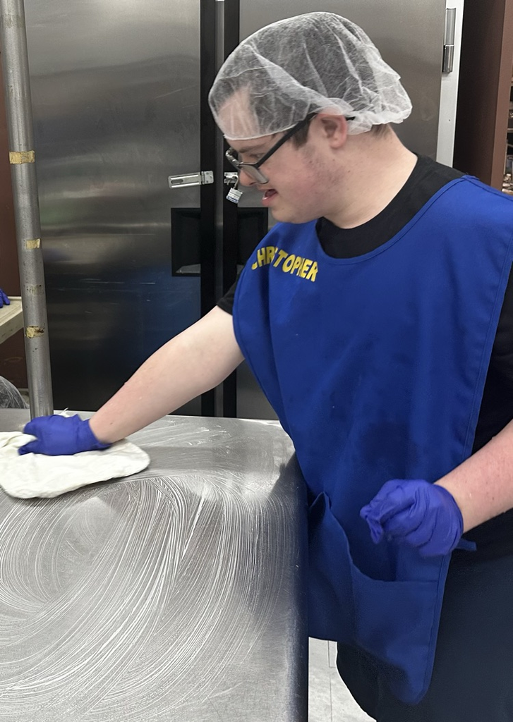 Student cleaning kitchen table.