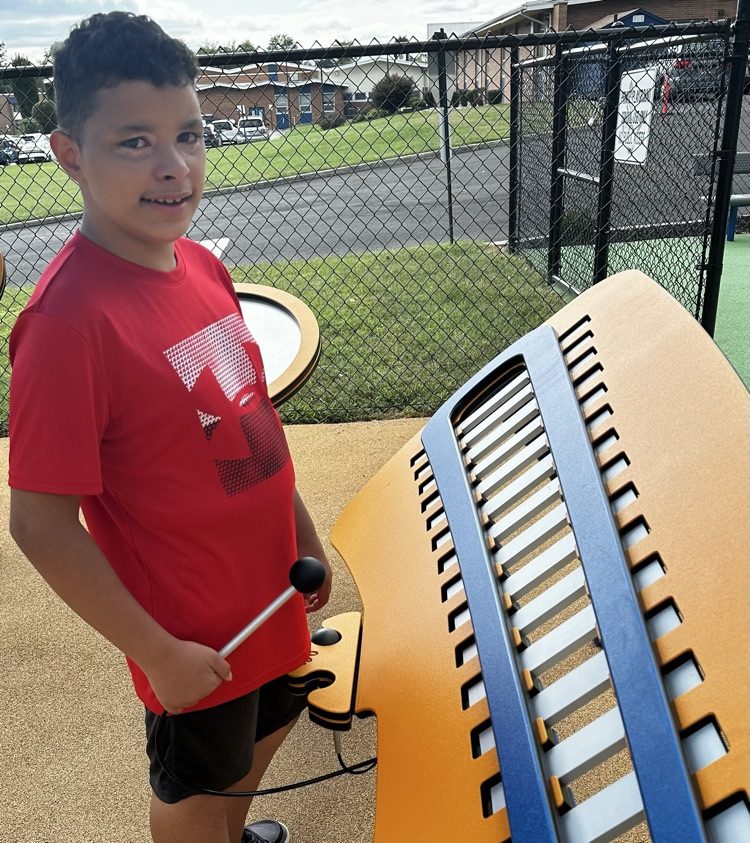 Student playing playground instrument