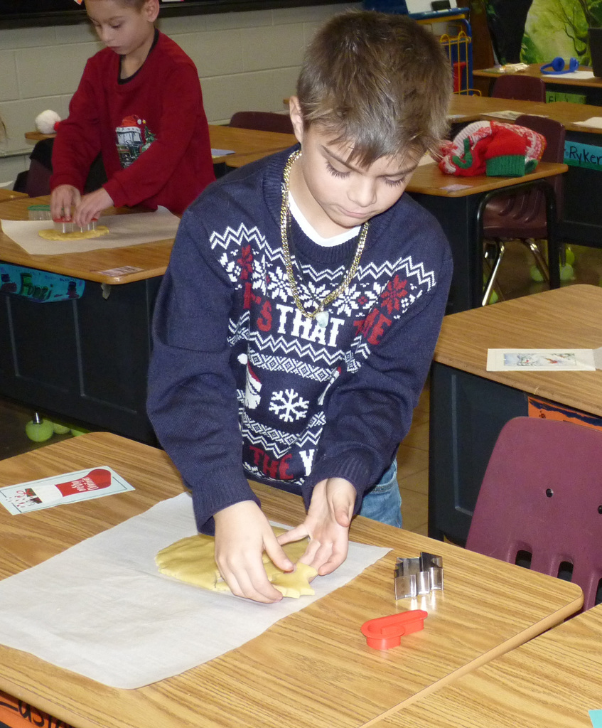 2nd graders cut out cookies.