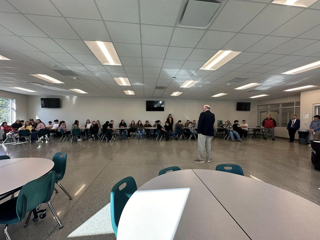 students sitting in front of a speaker