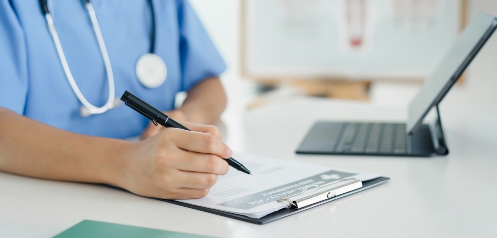 nurse writing on form