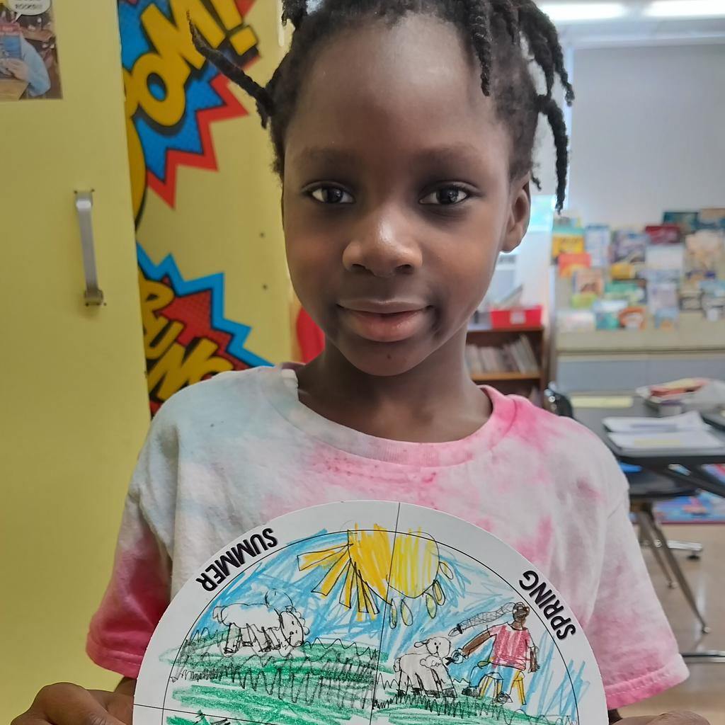 3rd grader showing off the four seasons on a farm wheel