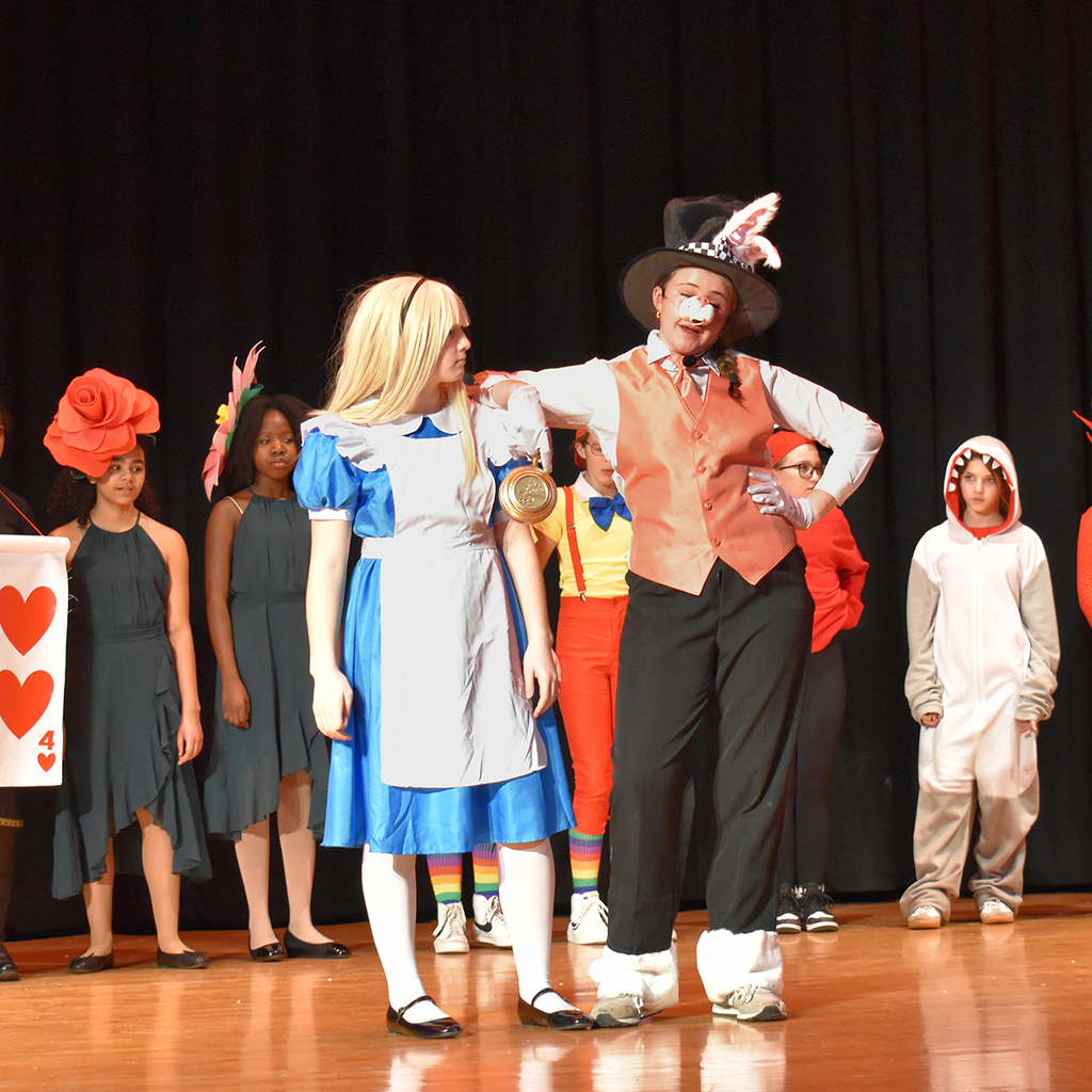 Scene from Alice in Wonderland with Alice and the Rabbit center stage