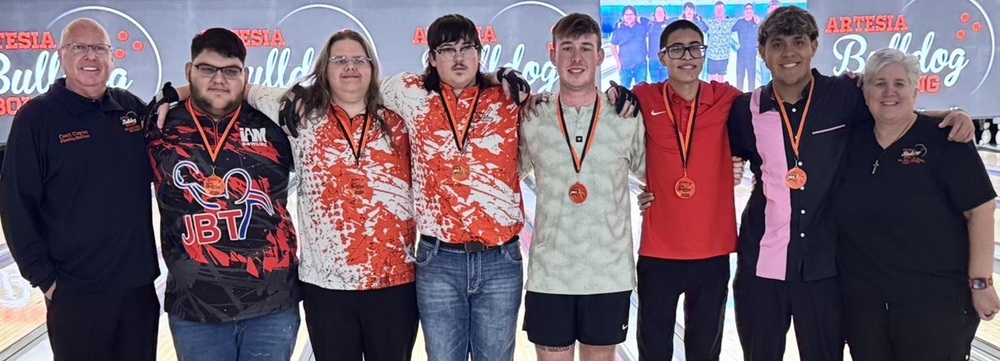 Six male teens stand in a line posing for a photo with a male coach and a female coach.