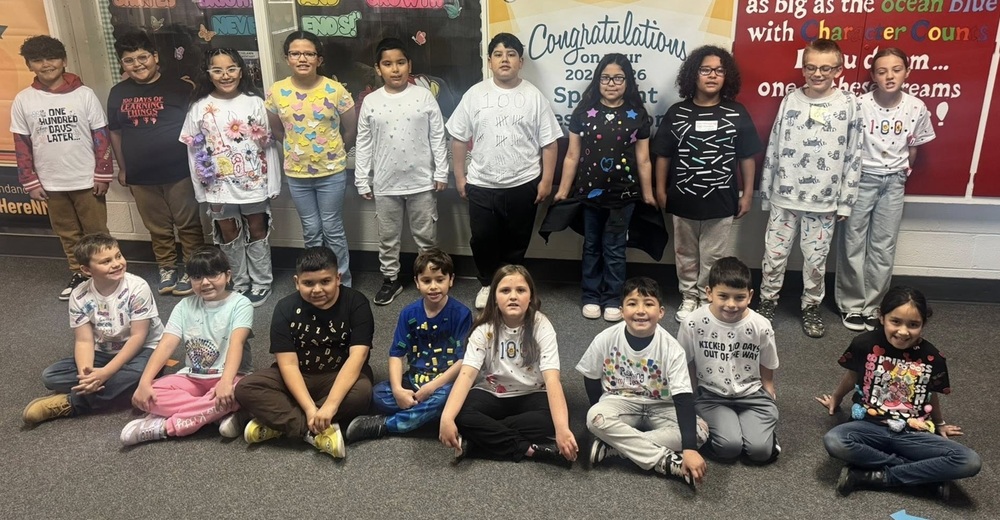 A group of children wearing shirts decorated with multiples of small items poses for the camera.