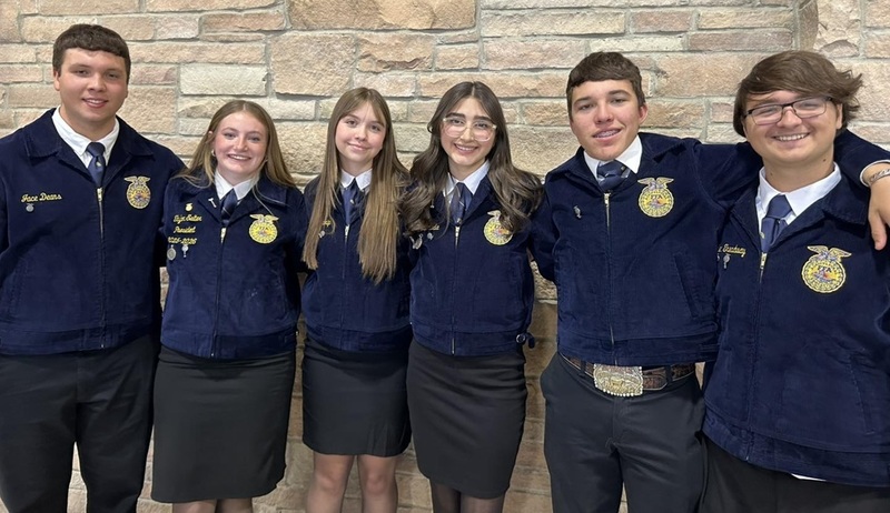 Three teen boys and three teen girls in blue FFA jackets pose for a photo.