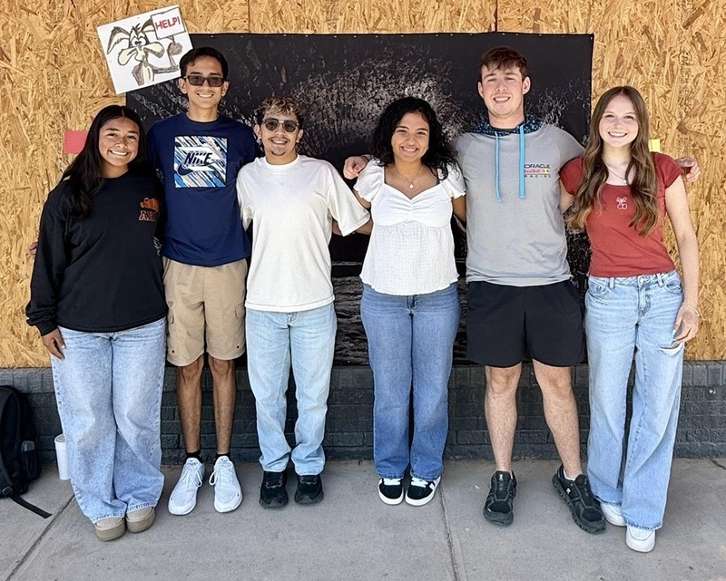 Three male teens and three female teens stand in a row as they pose for a photo.