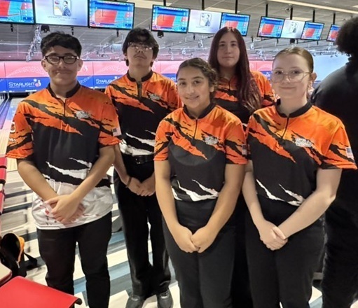 Two male and three female teens in orange, black and white bowling shirts pose for a photo.