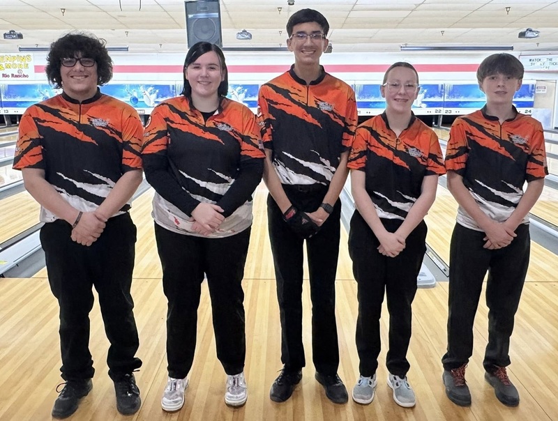 Three male and two female teens in orange, black and white bowling shirts pose for a photo.