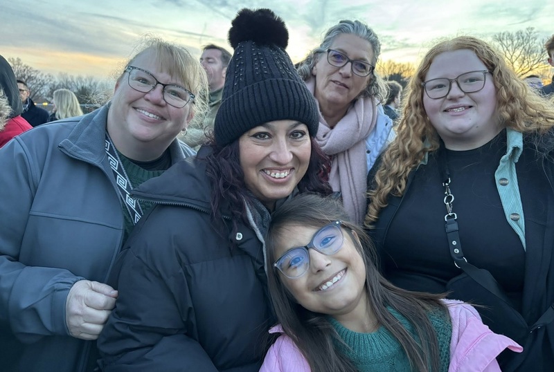 Four women and a female child pose for a photo.