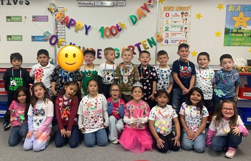 A group of children pose for the camera wearing shirts decorated with multiples of small items.
