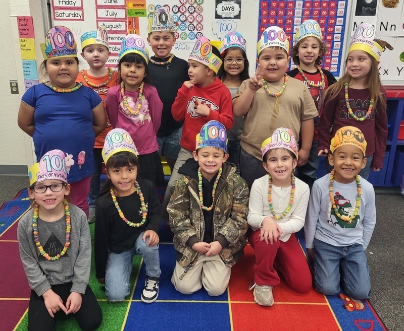 A group of children pose for the camera wearing shirts decorated with multiples of small items.