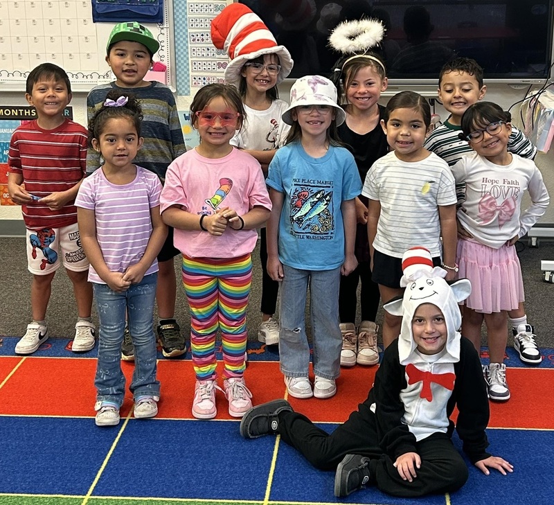 A group of children in striped hats and clothing poses for a photo.