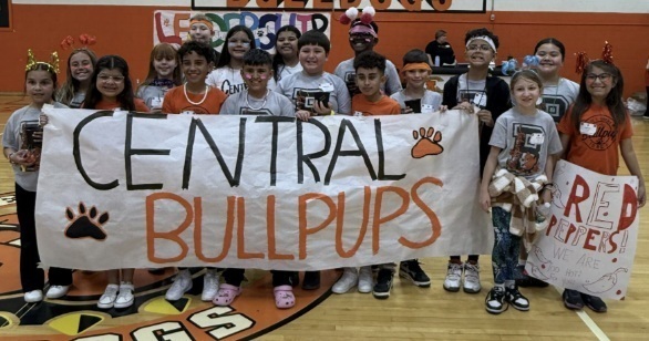 A group of children hold a banner reading "Central Bullpups."