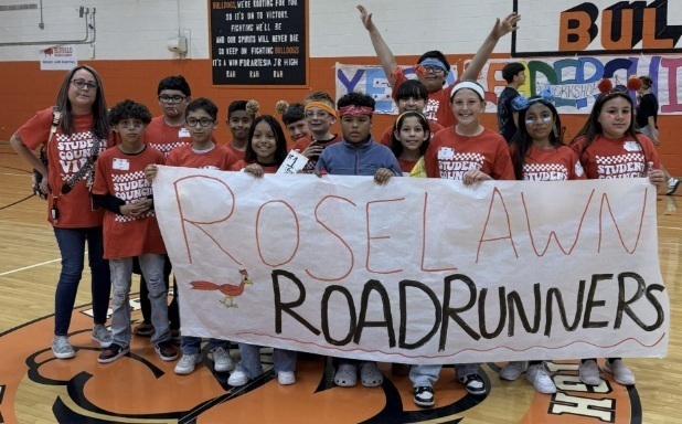 A group of children hold a banner reading "Roselawn Roadrunners."