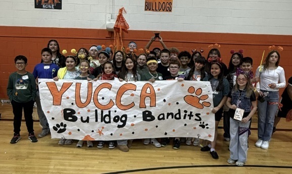 A group of children hold a banner reading "Yucca Bulldog Bandits."