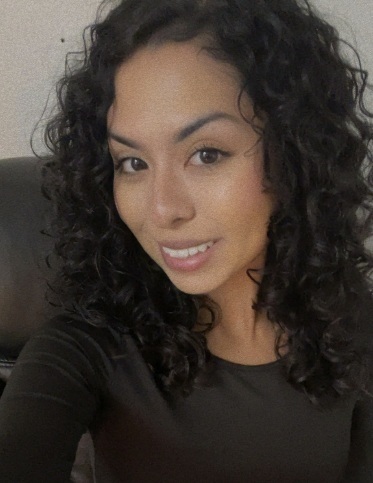 A woman dressed in black poses for a photo.