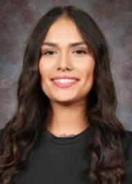A teen girl in a black shirt poses for a photo.