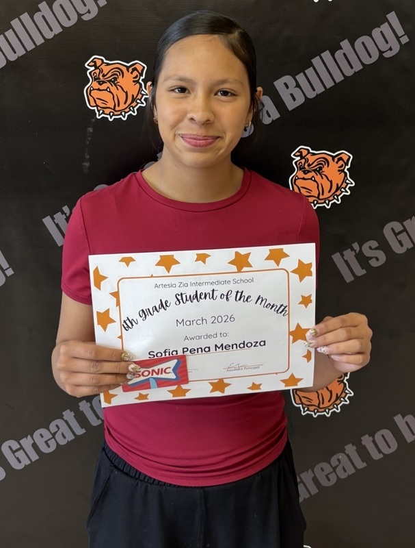 A preteen girl in a red top holds a certificate reading "Sixth-Grade Student of the Month".