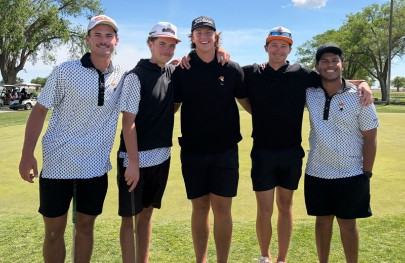 Five teen boys in golf clothes pose for a photo.