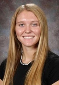 A teen girl with long blonde hair and a black top smiles for the camera.