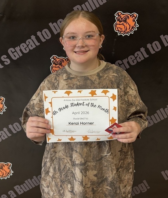 A teen girl in a camouflaged shirt holds a sign reading "Sixth-Grade Student of the Month".