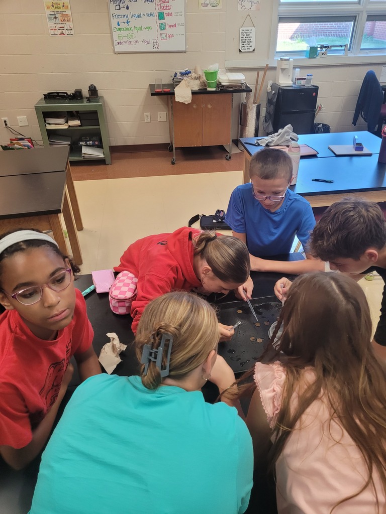 7th graders balancing water drops on pennies