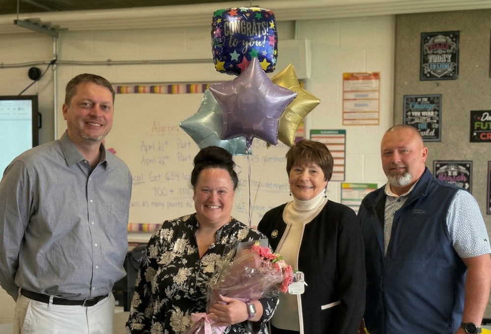 Group photo celebrating the 2026 Teacher of the Year. From left to right: Assistant Superintendent Joe Westendorf, Teacher of the Year Jennifer Harvey, Superintendent Mary Ronan, and Principal Mark Gabbard, all smiling in a school setting.