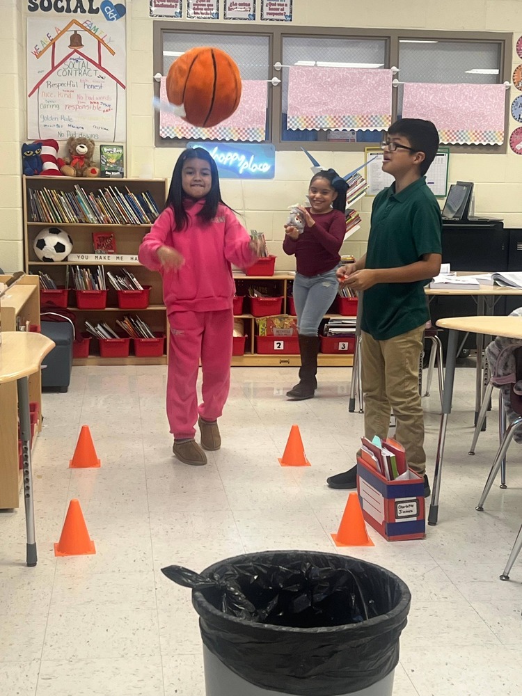 student throwing basketball in trashcan