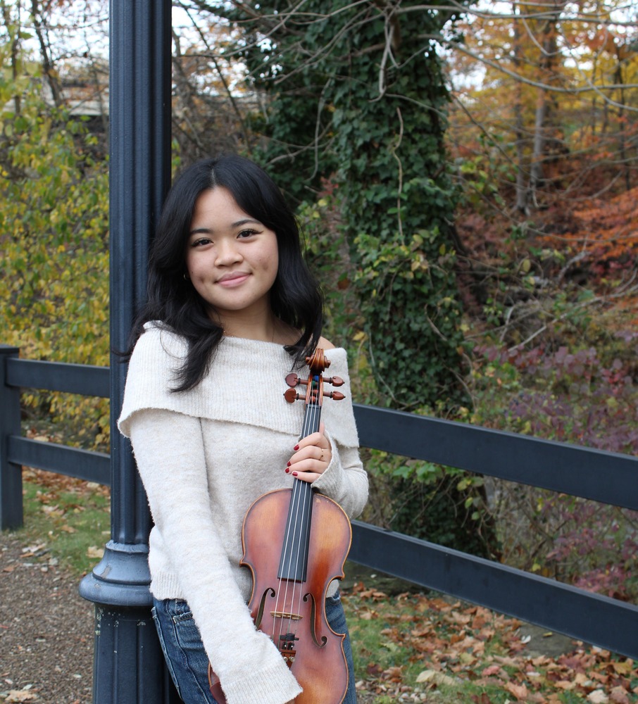 Senior Soloist Amie Nguyen holding violin