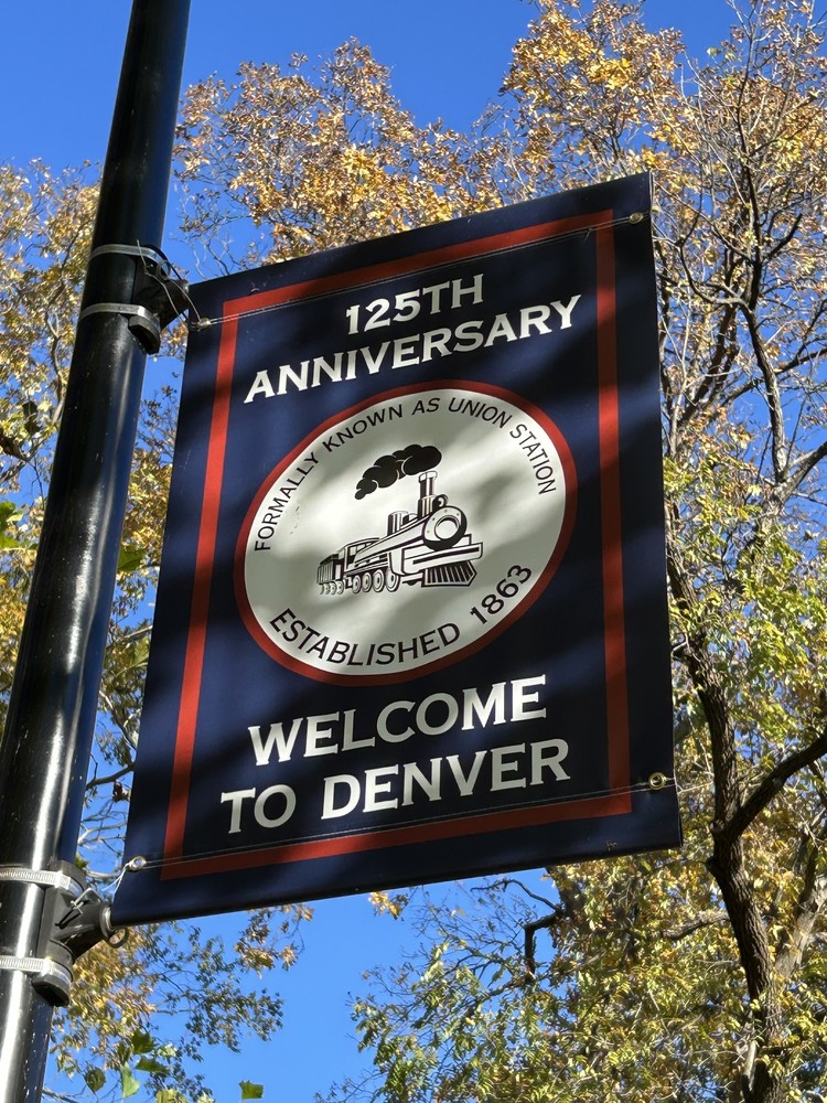 blue banner with white writing stating 125th Anniversary and Welcome to Denver