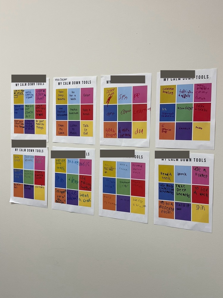 Eight student-created “My Calm Down Tools” charts displayed on a classroom wall, each featuring