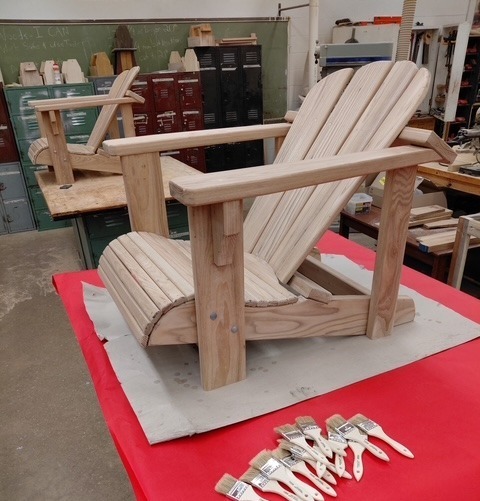 Adirondack chair with paintbrushes, ready to stain