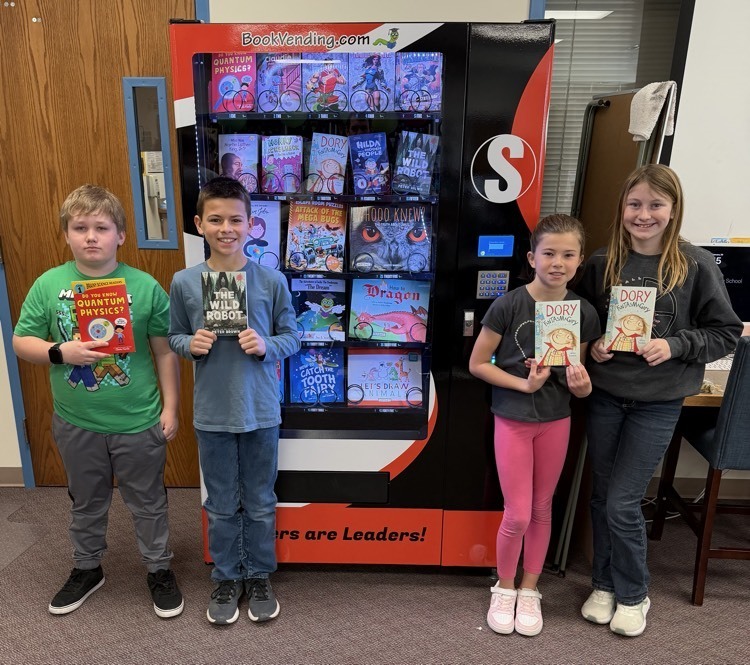 The image shows elementary students getting a book from the new book vending machine donated to Southern Elementary by the local Kiwanis Club  
