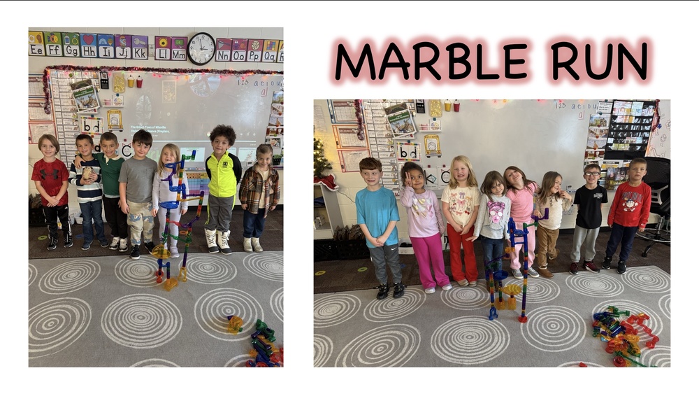 Elementary students stand in a classroom beside colorful marble run structures they built together. The students are smiling and posing next to tall marble tracks made from plastic pieces, demonstrating hands-on STEM learning and teamwork during a marble run activity.