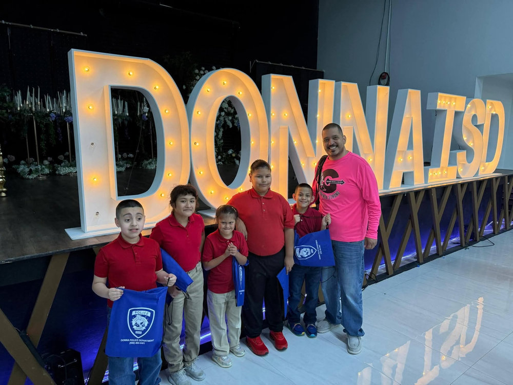 students and teacher stand in front of Donna sign