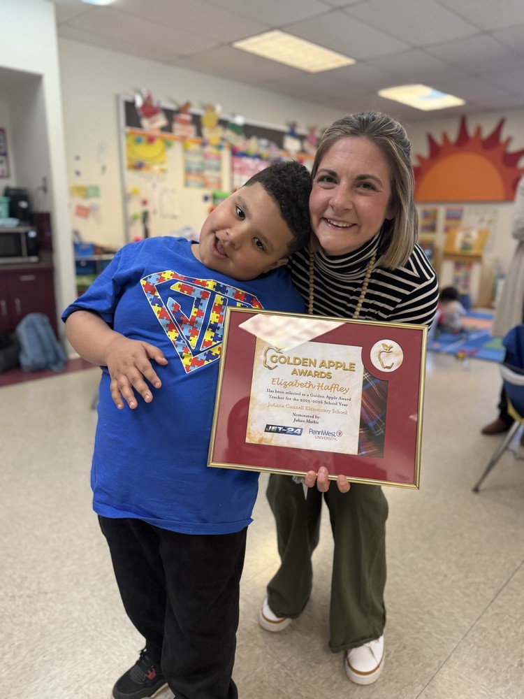 Mrs. Haffley received the golden apple award and is standing with her Student, Julian, who nominated her.