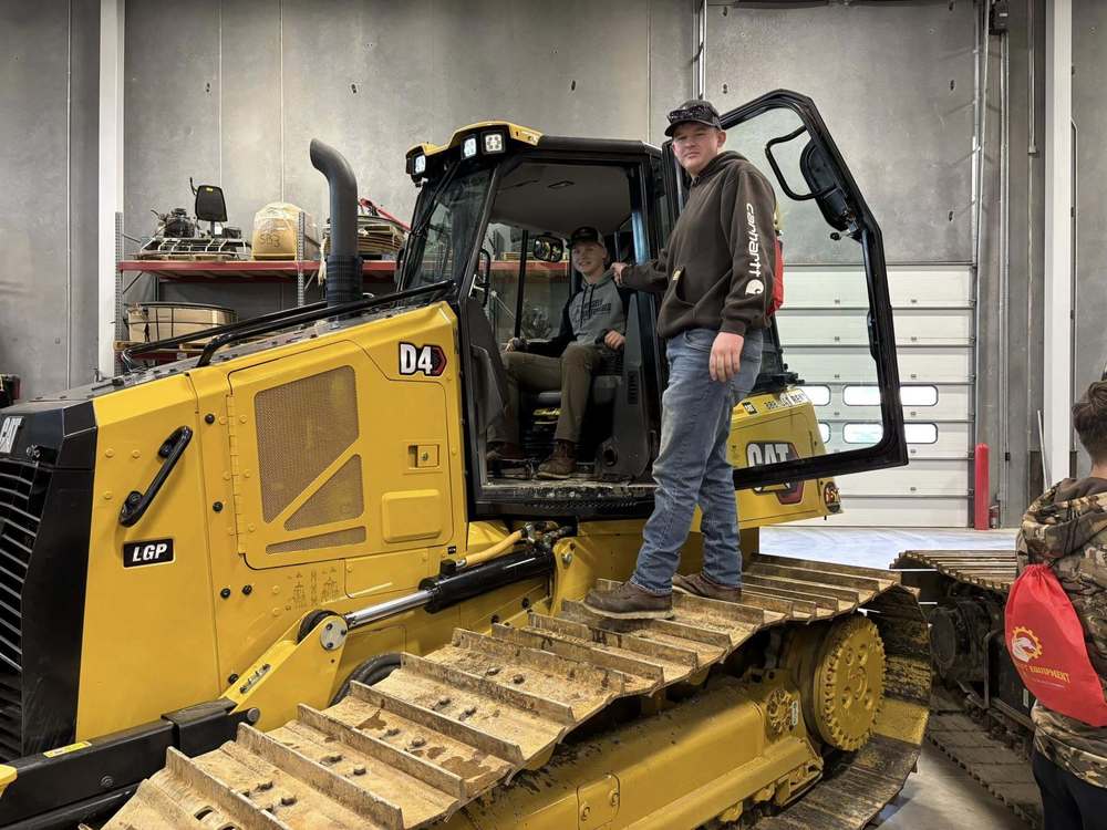 Two HATC students pose on piece of diesel equipment