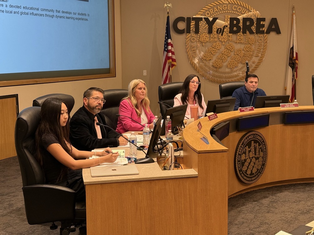 A photo of 5 board members sitting at a wooden dias. City of Brea sign hangs in the background