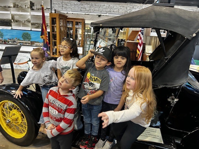 Kindergarteners posing with an old car at the Ash Fork Museum