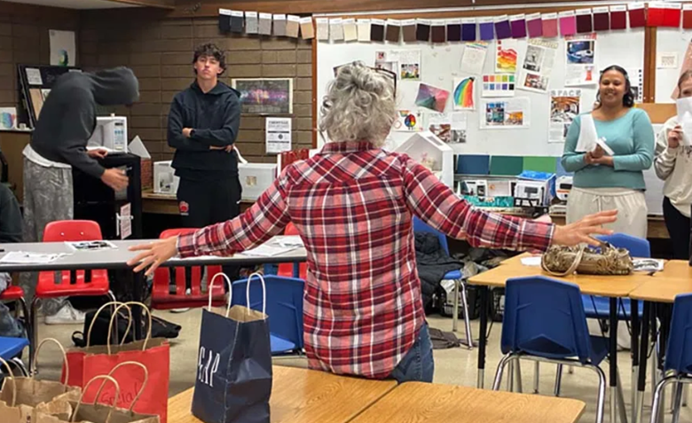 Teacher talking to students in a classroom 