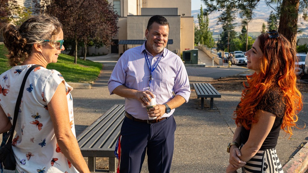 Superintendent Hattrick talk to mothers dropping off their students on the first day of high school